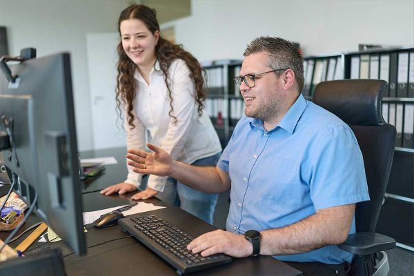 Mitarbeiter von Blank & Wilhelm bei der gemeinsamen Beratung am Computer